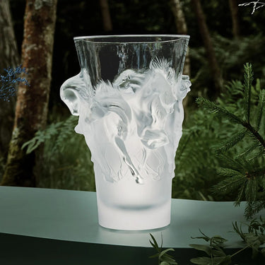 Decorative glass vase with horse design in an alpine and woodland setting. Showing the horses luminescent in the focal point. 