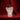Decorative glass vase with artistic design on a red surface with red curtains in the background. The vase takes centre stage. 